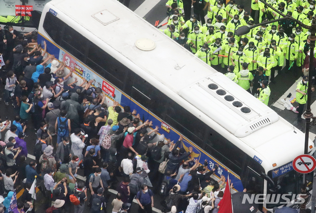 [서울=뉴시스]김명원 기자 = 지난 15일 서울 종로구 광화문 광장 열린 보수단체 8·15 대규모 집회 참가자들이 경찰 저지선을 뚫고 사직로에서 청와대로 가는길로 몰려와 경찰들과 대치하고 있는 가운데 일부 집회 참가자들이 경찰 버스를 넘어트리려는 듯 밀고 있다. 2020.08.15. kmx1105@newsis.com