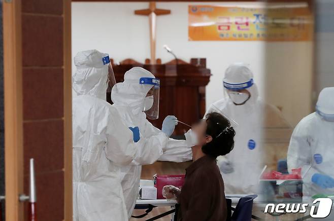 19일 오전 서울 중랑구 금란교회 예배당에 마련된 신종 코로나바이러스 감염증(코로나19) 선별진료소에서 중랑구 보건소 의료진이 피검사자의 검체를 채취하고 있다. /뉴스1 © News1 구윤성 기자