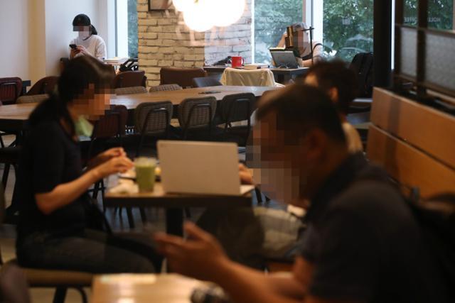 사회적 거리두기 2단계가 조치 중인 21일 서울의 한 카페에서 마스크를 착용한 이용객과 착용하지 않은 이용객들이 시간을 보내고 있다. 연합뉴스
