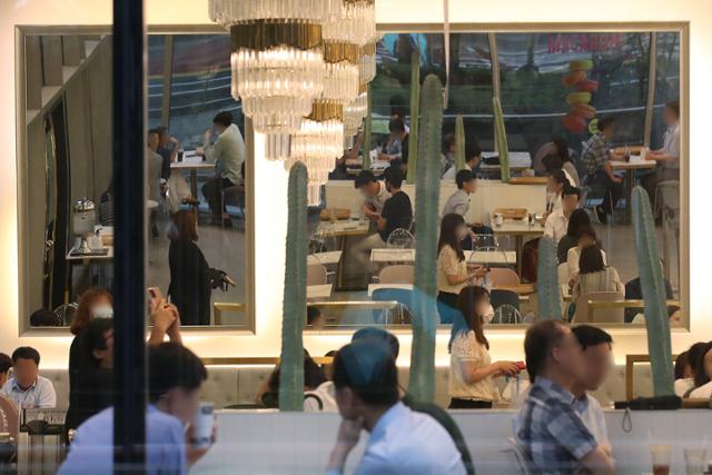 사회적 거리두기 2단계가 조치 중인 21일 서울의 한 카페에서 마스크를 착용하지 않은 다수 이용객들이 대화를 하고 있다. 연합뉴스