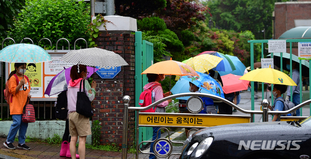 [광주=뉴시스] 류형근 기자 = 많은 비가 내리고 있는 18일 오전 광주 남구 봉선동 한 초등학교 앞에서 어린이들이 우산을 쓰고 등교를 하고 있다. 2020.06.18. hgryu77@newsis.com