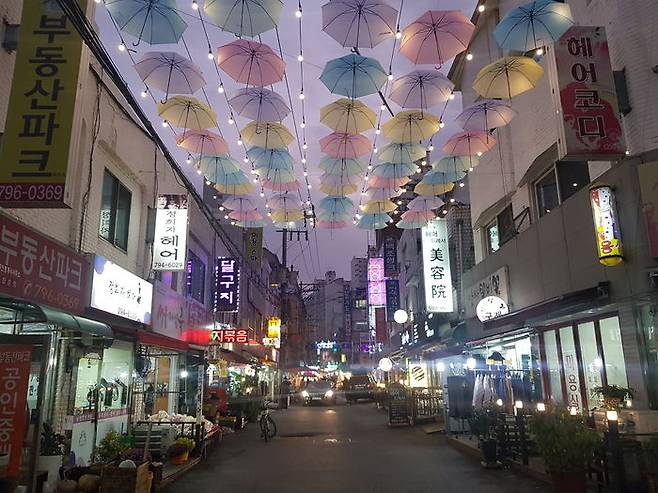 어두웠던 밤하늘을 밝히는 우산이 상가를 찾은 사람들의 눈길을 끌고 있다.