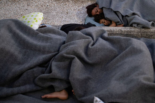 11일(현지시간) 그리스 레스보스섬의 모리아 난민캠프 인근 도로 위에서 난민들이 잠들어 있다. 레스보스｜로이터연합뉴스
