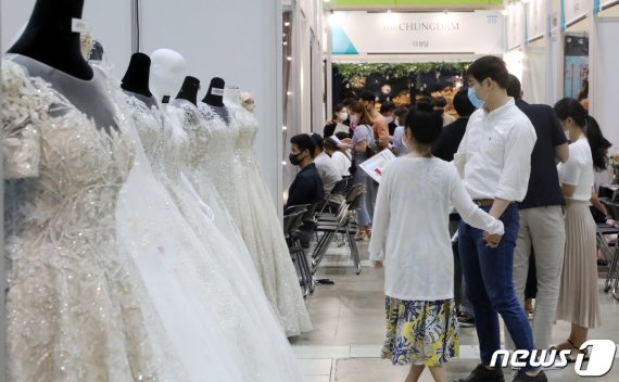 예비 신혼부부들이 7월 서울 강남구 삼성동 코엑스에서 열린 '제54회 웨덱스코리아’에서 웨딩드레스를 살펴보고 있다.(사진은 기사와 무관) /사진=뉴스1