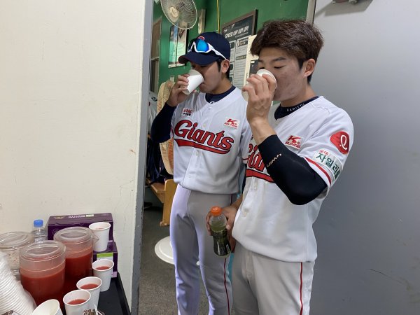 롯데 홍지훈 차혜성(왼쪽부터)이 건강음료를 마시며 목을 축이고 있다. 사진제공 | 롯데 자이언츠