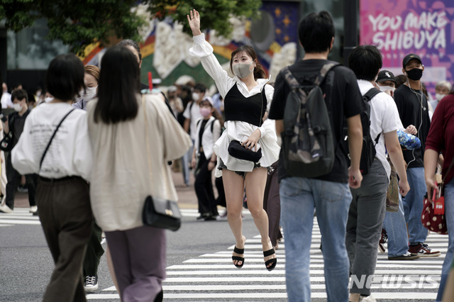 [도쿄=AP/뉴시스] 9월21일 일본 도쿄 시부야에 있는 한 건널목에서 코로나19 확산 예방을 위해 마스크를 쓴 한 여성이 점프하고 있다. 2020.09.21.