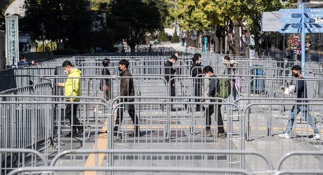 한글날인 9일 서울 광화문 일대에 차벽과 펜스가 설치되어 있는 가운데 세종문화회관 앞에서 시민들이 미로를 걷듯 발걸음을 옮기고 있다./ 고운호 기자