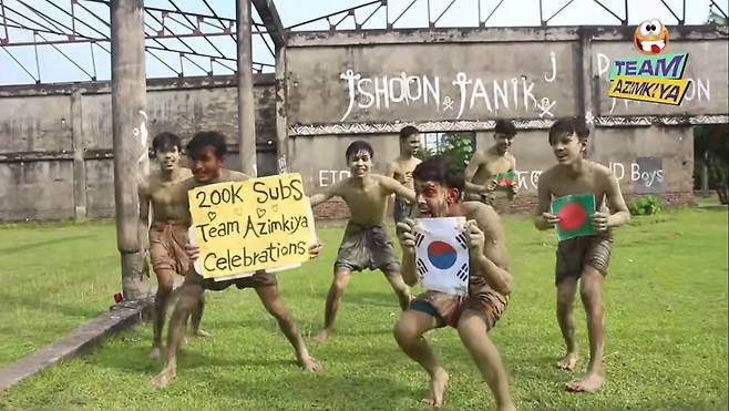 방글라데시 유튜버 '팀 아짐키야'가 구독자 20만 명 돌파 기념으로 게재한 영상에서 온 몸에 진흙을 바른 채 방글라데시 국기와 태극기를 흔들며 춤을 추고 있다. [유튜브 캡처]