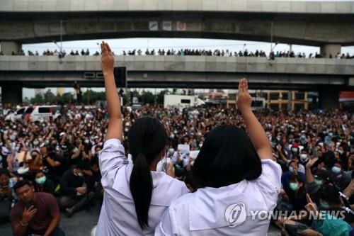 반정부 시위대 앞에서 세손가락 경례를 하는 교복 차림의 태국 여학생들 2020.10.19 [로이터=연합뉴스]