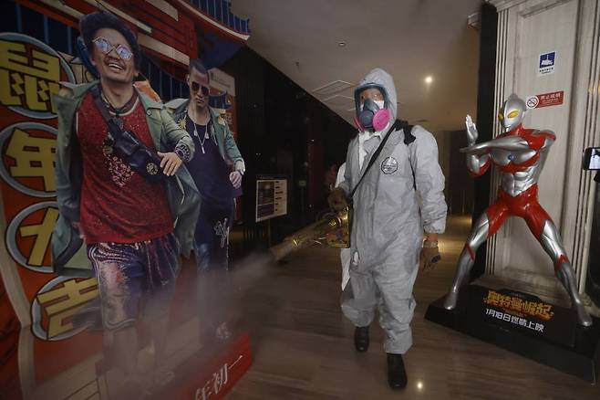 [베이징=AP/뉴시스] 중국 베이징에서 지난 7월 24일 자원봉사자들이 블루 스카이 구조대와 함께 코로나19로 폐쇄 후 재개관하는 영화관을 소독하고 있다.