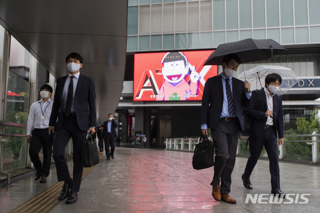 [도쿄=AP/뉴시스]23일 일본 도쿄에서 신종 코로나바이러스 감염증(코로나19) 예방을 위해 마스크를 쓴 시민들이 빗속을 걷고 있다. 2020.10.23.