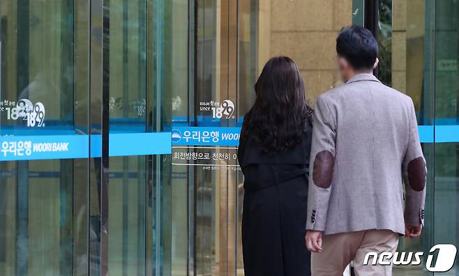 서울 중구 우리은행 본점에 직원들이 출근하고 있다. 우리은행 측은 "임원 5명이 신종 코로나바이러스 감염증(코로나19) 확진 판정을 받았다"고 지난 25일 밝혔다. /뉴스1 © News1 이승배 기자