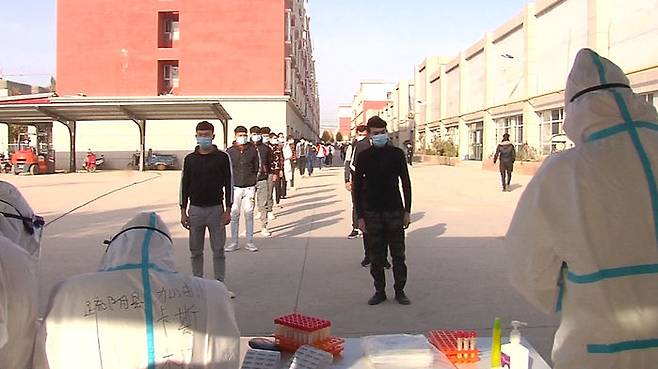 신장위구르 주민들이 줄지어 코로나19 핵산검사를 받는 모습