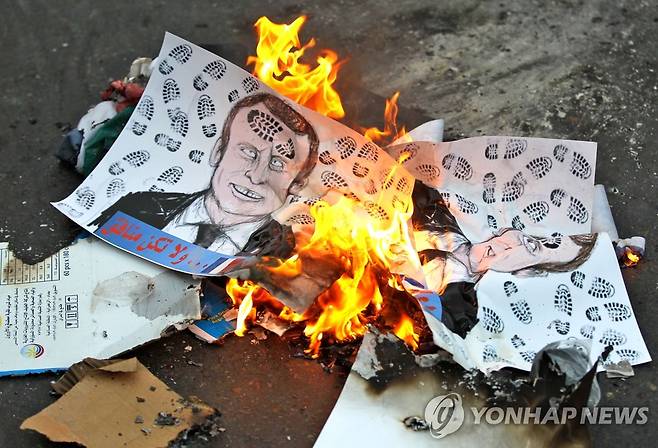 '신발 자국' 마크롱 얼굴 그림 불태우는 이라크 시위대 (바그다드 AFP=연합뉴스) 26일(현지시간) 이라크 수도 바그다드의 프랑스 대사관 앞에서 시위대가 에마뉘엘 마크롱 프랑스 대통령의 얼굴에 신발 자국이 찍힌 그림을 불태우고 있다. 아랍 국가에서는 마크롱 대통령이 이슬람교 선지자 무함마드를 풍자한 만평을 옹호했다는 이유로 프랑스 제품 불매 운동이 확산하고 있다. sungok@yna.co.kr