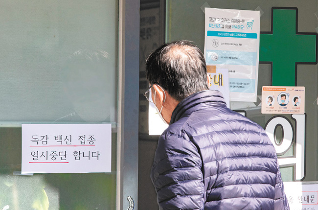 10월 23일 서울 한 병원에 독감 백신 접종을 일시 중단한다는 안내문이 붙어 있다. 독감 백신 접종 후 사망 사례가 이어지면서 일부 지방자치단체와 의료기관은 자체적으로 백신 접종을 일시 중단했다. [뉴스1]
