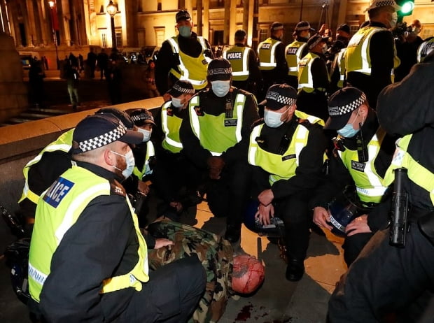 5일(현지시간) 영국 런던 중심가에서 경찰이 부상을 입은 시위자를 체포하고 있다. 사진=AP