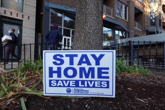 미국 중서부 일리노이주 시카고의 한 식당 앞에 11일 "집에 머물며 생명을 구하라"는 푯말이 세워져 있다. 시카고=AFP 연합뉴스