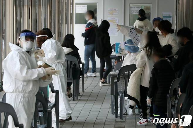 13일 오후 서울 동대문구보건소에 마련된 신종 코로나바이러스 감염증(코로나19) 선별 진료소에서 시민들이 줄을 서고 있다./사진제공=뉴스1