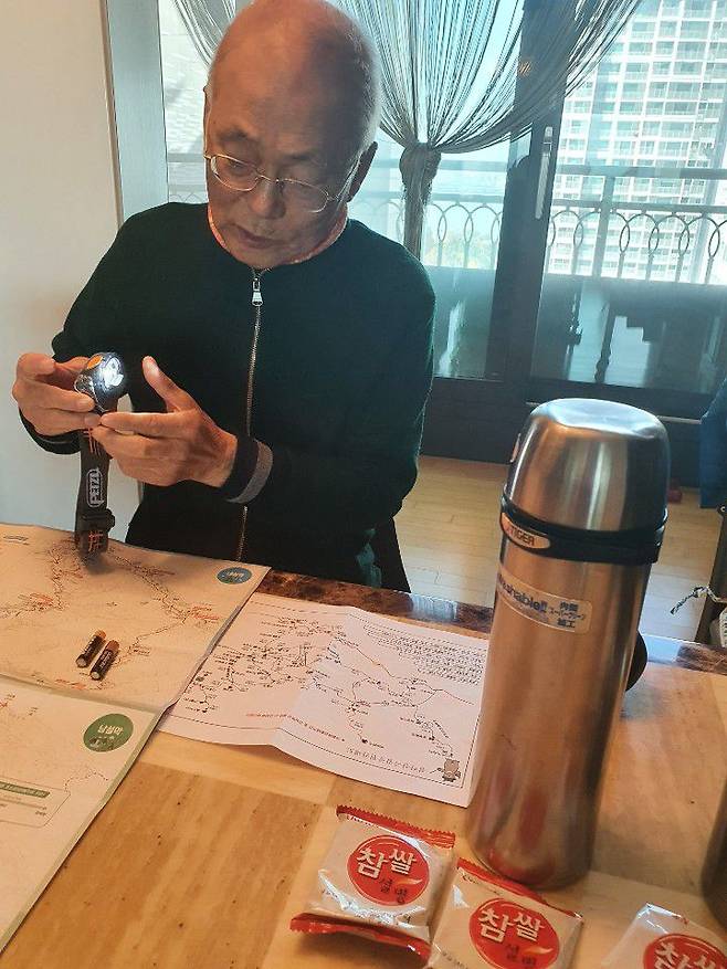 지난 11일 본지와 만난 조씨. 그는 착용했던 헤드렌턴을 켜고, 설악산 사진을 놓고 당시 상황에 대해 설명했다.