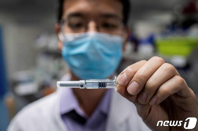 한 중국 의료진이 코로나19 백신 주사약을 들어보이고 있다. © AFP=뉴스1