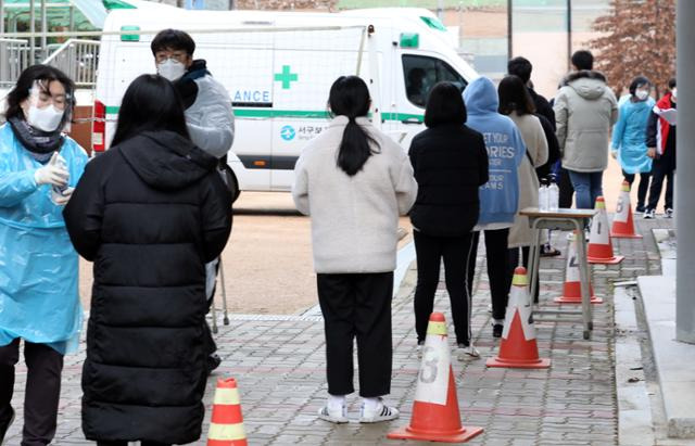 지난 19일 오후 신종 코로나바이러스 감염증(코로나19) 확진자가 나온 인천 서구 불로중학교에서 학생들이 이동선별진료소에서 검사를 받기 위해 줄을 서서 기다리고 있다. 뉴시스