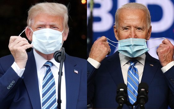 도널드 트럼프 미국 대통령(왼쪽)과 조 바이든 미국 대통령 당선자가 각각 마스크를 쓰려고 하고 있다. 내년 1월 20일로 예정된 미 대통령 취임식에 전임자인 트럼프 대통령이 불참할 가능성이 미 조야에서 제기되고 있다. [AFP·로이터=연합뉴스]