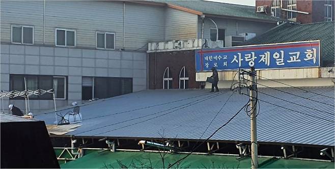 사랑제일교회 옥상에서 신도로 추정되는 인물이 인화물질을 옮기고 있는 모습 (사진=연합뉴스)