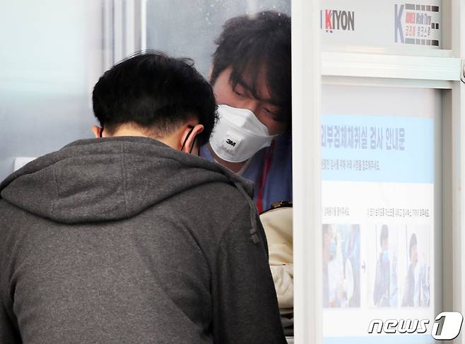 선별진료소에서 의료진들이 내원객에게 코로나19 검체 채취를 하고 있다./뉴스1 © News1 송원영 기자