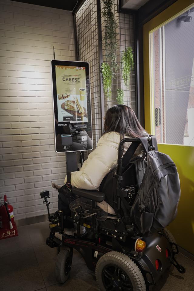 지난 2일 서울 종로구 혜화동의 한 카페에서 문씨가 휠체어 탑승한 채로 무인주문기를 조작해보고 있다. 팔을 충분히 뻗지 않는 이상 조작이 힘들다.