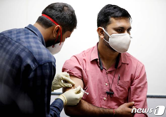 인도 서부 구자라트주 최대 도시 아마다바드에서 의료진에게 신종 코로나바이러스 감염증(코로나19) 백신을 접종하고 있다. © 로이터=뉴스1