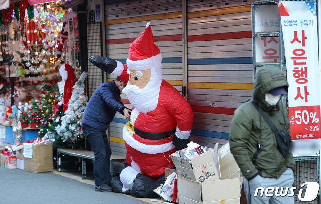 크리스마스를 닷새 앞둔 20일 서울 동대문구 창신동 문구거리에서 한 자영업자가 쓰러지는 산타 인형을 일으켜 세우고 있다. 2020.12.20/뉴스1 © News1 이성철 기자