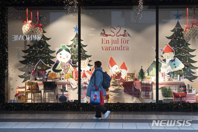 [스톡홀름=AP/뉴시스]10일(현지시간) 스웨덴 스톡홀름에서 한 남성이 크리스마스 테마 상점 앞을 지나고 있다. 스웨덴의 코로나19 누적 환자 수는 16만2240명, 사망자는 6057명으로 집계됐다. 2020.11.11.