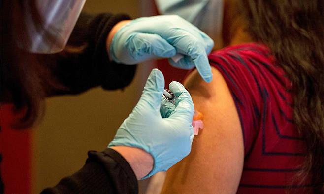 지난 21일(현지시간) 미국 코네티컷주 하트퍼드 병원에서 한 의사가 모더나의 신종 코로나바이러스 감염증(코로나19) 백신을 접종받고 있다. 하트퍼드=AFP연합뉴스