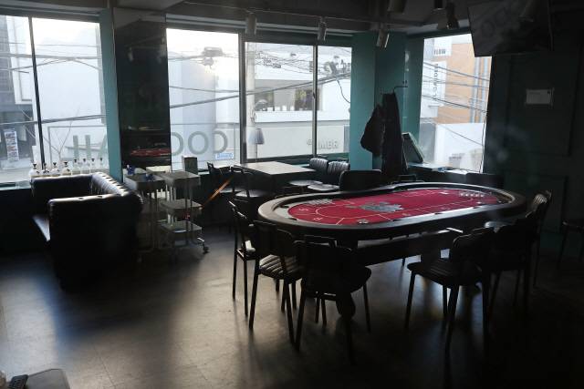 코로나19 대표적인 사각지대로 꼽혔던 ‘홀덤펍(술 마시면서 카드 게임 등을 즐길 수 있는 주점)’ 운영이 19일부터 열흘간 중단된 가운데 지난 20일 서울 시내의 한 홀덤펍 테이블 위에 카드가 흩어져 있다./연합뉴스