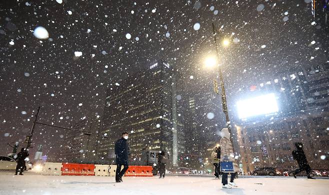 눈이 내리고 있는 6일 오후 서울 종로구 광화문네거리에서 시민들이 발걸음을 옮기고 있다. /뉴시스