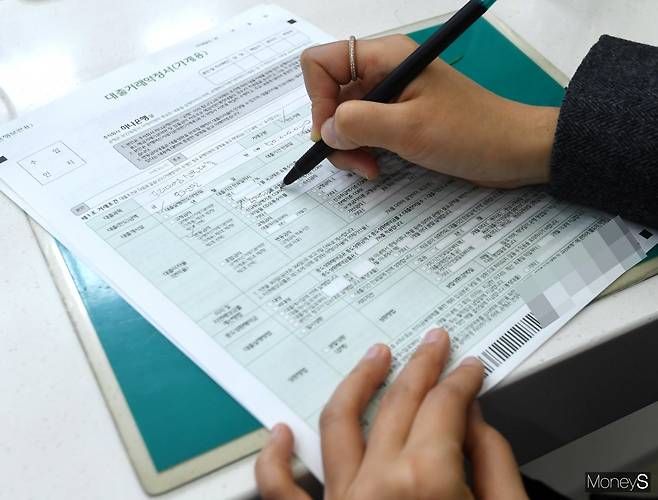 5일 대출자가 시중은행 대출 창구에서 대출거래약정서를 쓰고 있다/사진=장동규 기자