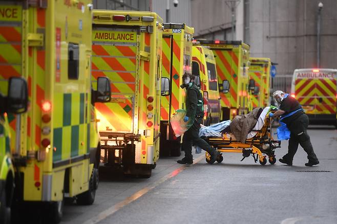 영국 런던의 로열 런던 병원에서 5일(현지 시각) 의료 요원들이 구급차로 이송한 환자를 옮기고 있다. 보리스 존슨 영국 총리는 이날 0시부터 잉글랜드 전역을 대상으로 3차 봉쇄조치를 도입한다고 발표했다. ⓒ 연합뉴스