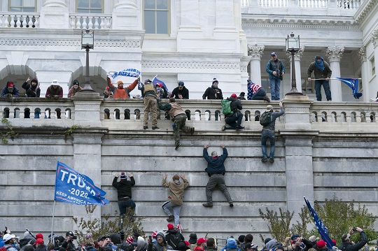 도널드 트럼프 대통령의 지지자들이 워싱턴에서 미 국회의사당 서쪽 벽을 기어오르고 있다. AP뉴시스