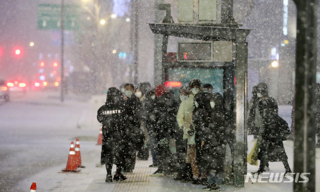 [서울=뉴시스]이영환 기자 = 연일 한파가 이어지며 눈이 내리고 있는 6일 오후 서울 종로구 광화문네거리에서 시민들이 버스를 기다리고 있다. 2021.01.06. 20hwan@newsis.com