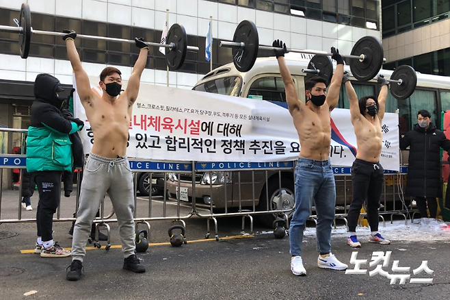 대한민국 기능성 피트니스 협회(Korea Functional Fitness Association) 회원들이 8일 서울 여의도 더불어민주당 당사 앞에서 상의를 탈의한 채 바벨을 이용한 운동동작을 선보이고 있다. 이은지 기자