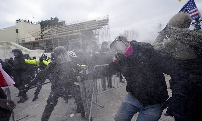 도널드 트럼프 미국 대통령 지지 시위대가 지난 6일(현지시간) 워싱턴DC 연방 의사당에서 경찰의 바리케이드를 뚫고 난입하고 있다. 워싱턴=AP연합뉴스