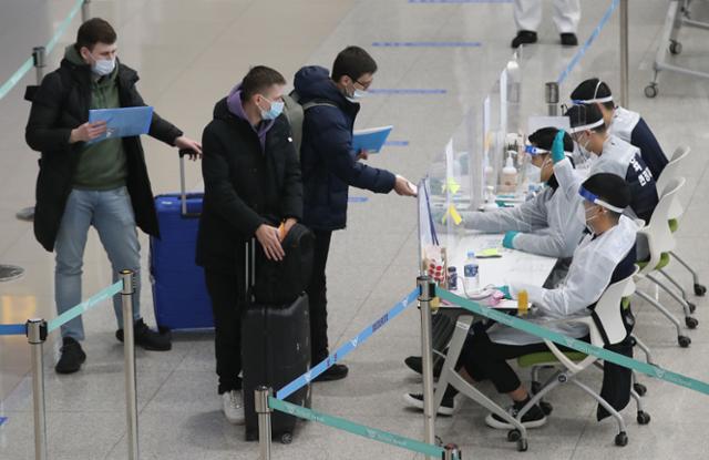 8일 오후 인천국제공항 제2여객터미널에서 방역 관계자들이 해외 입국자들에게 동선을 안내하고 있다. 뉴스1