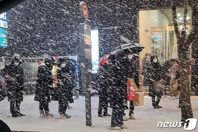 북극발 찬공기 영향으로 중부지역과 내륙을 중심으로 한파가 이어지고 있는 6일 저녁 서울 강남역 인근에서 시민들이 눈발을 맞으며 버스를 기다리고 있다.