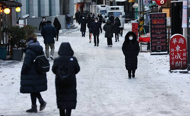 많은 양의 눈이 내린 7일 오전 서울 종로구 광화문역 인근에서 출근길 시민들이 길을 걷고 있다. 연합뉴스