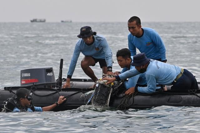 10일 인도네시아 해군 잠수사들이 전날 오후 스리위자야항공 SJ182편이 추락한 자카르타 북서쪽 해상 '풀라우 스리부' 지역에서 잔해를 인양하고 있다. 자카르타=AFP 연합뉴스