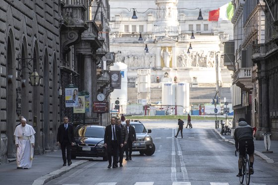 프란치스코 교황(맨 왼쪽)이 15일(현지시간) 신종 코로나바이러스 감염증(코로나19) 종식 및 감염자 쾌유를 위해 기도하려고 이탈리아 로마 시내의 산타 마르첼로 알 코로소 성당으로 걸어가고 있다. AP=연합뉴스