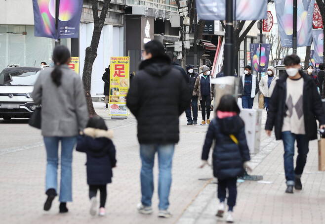 A family strolls through the Myeong-dong shopping district in central Seoul on Jan. 3. (Yonhap)