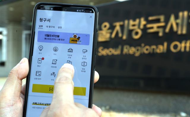 (서울=연합뉴스) 카카오톡이나 휴대전화 문자메시지 등을 통해 국세 고지서를 받아보고 바로 세금을 납부할 수 있게 된 지난 12월 22일 한 시민이 관련 앱을 살펴보고 있다.