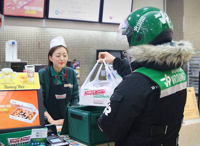a Vroong delivery worker collects an order of donuts. (Mesh Korea)