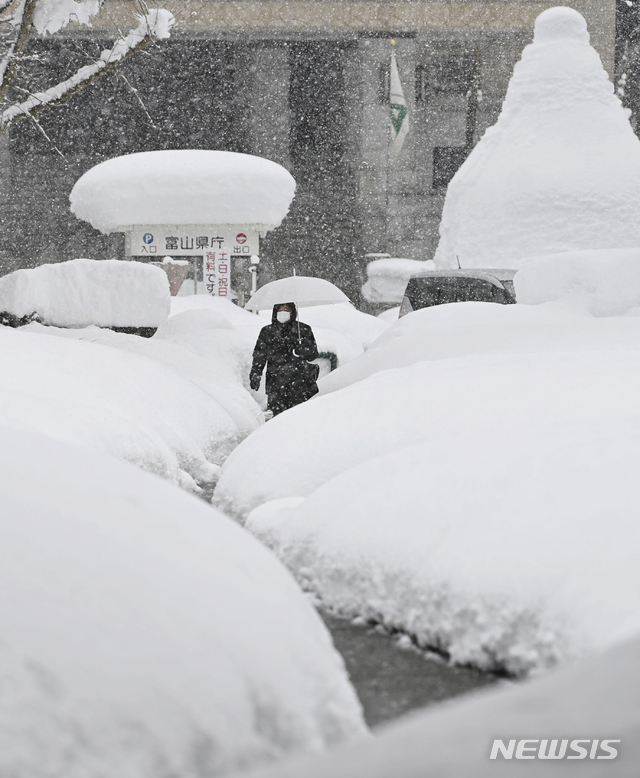 [도야마=AP/뉴시스]일본 도야마에 기록적인 폭설이 이어진 가운데 11일 우산 쓴 한 시민이 허리 높이까지 눈이 쌓인 거리를 걷고 있다. 도야마는 지난 7일 이후 내린 폭설로 122cm의 적설량을 기록했으며 주변 지역에 평년 대비 2~10배 많은 눈이 내리고 8명이 사망했다고 기상청이 밝혔다. 2021.01.11.